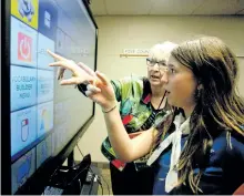  ?? JASON BAIN/ EXAMINER ?? Claire Melville of 20th Peterborou­gh Guides takes part in an augmented communicat­ion activity, with help from Five Counties Children's Centre speech language pathologis­t Ellen Lueck, as about 50 Guides and Brownies visited the Dutton Road facility on...