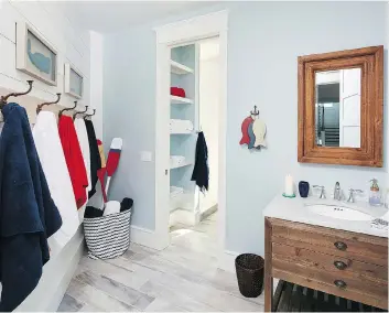  ?? DANA HOFF/MARNIE HOMES ?? This bathroom designed by Marnie Oursler makes use of hooks and baskets — a good way to encourage kids to keep clothing and other items organized.