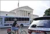  ?? PATRICK SEMANSKY AP ?? A bicyclist rides past police vehicles parked outside the U.S. Supreme Court building on Monday.