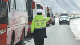  ?? ?? A police officer controls traffic on the route along which the students will travel.