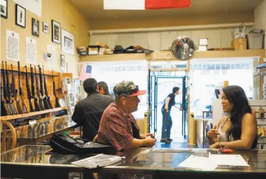  ?? Photos by James Tensuan / Special to The Chronicle ?? Above: Angel Castro (left) and Stephanie Timblin check out High Bridge Arms, which is closing next month. Below: Old boxes of shotgun shells are displayed at the store, whose owner has been frustrated by S.F.’s laws.