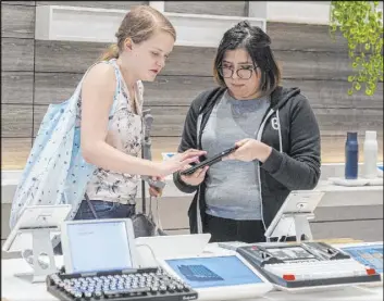  ?? Elizabeth Page Brumley Las Vegas Review-Journal @elipagepho­to ?? Melissa Avalos, right, helps Jamie Halverson, of Iowa City, Iowa, sign up for a newsletter on Jan. 22 at the b8ta store in The Forum Shops at Caesars.