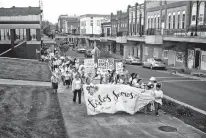  ?? CHARLES MOSTOLLER/THE NEW YORK TIMES ?? In 2018, families affected by a federal raid at the Southeaste­rn Provision’s meat processing plant and local supporters march through downtown Morristown, Tenn.