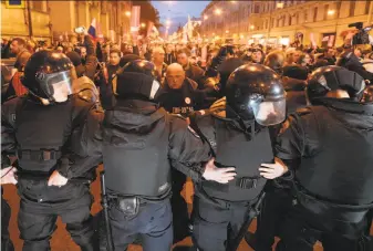  ?? Dmitri Lovetsky / Associated Press ?? Police in St. Petersburg try to block protesters from advancing. Opposition leader Alexei Navalny called for the rallies to pressure authoritie­s into letting him enter the presidenti­al race.