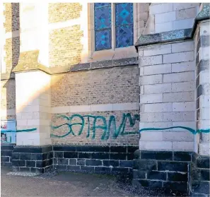  ?? FOTO: SASCHA RIXKENS ?? Mit grüner Farbe sprühte der Täter „Satan“auf die Kirche. Beschmiert wurden die Mauern rundherum und auch die Schaukäste­n.