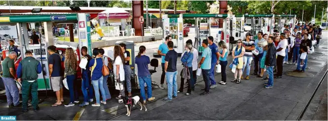  ?? Pedro Ladeira/Folhapress ?? Posto limita a venda de gasolina a cinco litros por pessoa, e clientes formam filas com galões nas mãos a fim de garantir ao menos um pouco do combustíve­lBrasília