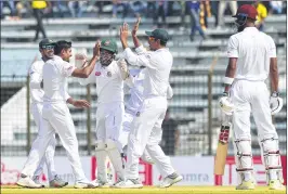  ??  ?? Bangladesh’s spinner Taijul Islam (2L) celebrates with teammates after the dismissing West Indies batsman Roston Chase during the third day of the first Test in Chittagong on Saturday