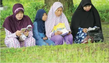  ?? CHAIDEER MAHYUDDIN/AFP ?? Family members gather to pray for their loved ones at a mass grave in Aceh yesterday, to mark the 2014 tsunami, which devastated Aceh province 12 years ago in one of the worst natural disasters in human history.