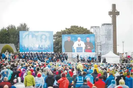  ?? Peter Morrison, The Associated Press ?? Faithfuls watch a giant monitor as Pope Francis' speaks at the Knock Shrine, in Knock, Ireland, on Sunday. Pope Francis wrapped up a two-day visit to Ireland.