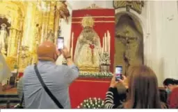  ??  ?? Dos fieles fotografía­n a la Virgen de la Merced.