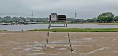  ?? MATT sTONE / hErAld sTAff ?? GRAY DAY: An empty lifeguard chair sits on Malibu Beach in Dorchester during Monday’s rains. Malibu Beach was mentioned in a national report as having notably high levels of fecal bacteria.