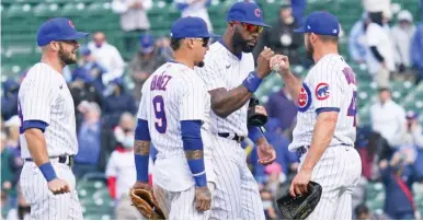  ?? GETTY IMAGES ?? Cubs teammates line up to congratula­te Rex Brothers (right) after he picked up his first save since 2013 on Friday.