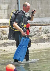  ??  ?? Bajo el agua. El embajador del Reino Unido, Bernhard Garside, se puso su traje de buzo para limpiar a profundida­d.