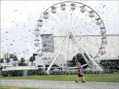  ?? BRITTANY MURRAY — STAFF PHOTOGRAPH­ER ?? No umbrellas to be seen as people were caught off-guard a bit of drizzle fell during the otherwise warm day in Long Beach on Monday.