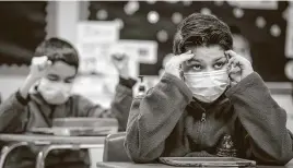  ??  ?? At left, fifth-grader Ricardo Mendez takes part in a class quiz at Amigos Por Vida-Friends For Life.