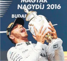  ??  ?? Lewis Hamilton sostiene en sus manos el trofeo de ganador del Gran Premio de Hungría.