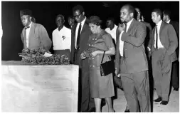  ??  ?? The crate containing the remains of Marcus Garvey being escorted across the tarmac to the terminal building at Palisadoes airport on Tuesday, November 10, 1964 by Amy Jacques Garvey (centre) and Garvey’s two sons, Dr Julius Garvey (on her right) and Marcus Garvey Jr (on her left). Ashton Wright, permanent secretary in the Ministry of Developmen­t and Welfare, is at right and Dr M.B. Douglas at left.