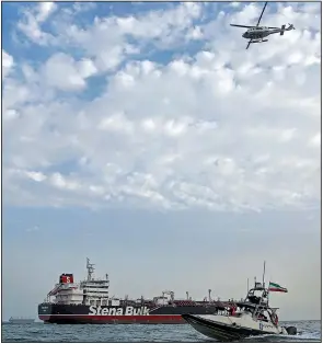  ?? AP/Mizan News Agency/HASAN SHIRVANI ?? The seized oil tanker remains in the Iranian port of Bandar Abbas on Sunday as a speedboat and an Iranian Revolution­ary Guard helicopter are seen nearby.