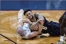  ?? Gerald Herbert Associated Press ?? NEW ORLEANS guard Nickeil Alexander-Walker, top, battles Lakers guard Alex Caruso for a loose ball in the first half.
