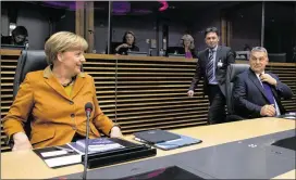  ?? VIRGINIA MAYO / ASSOCIATED PRESS ?? German Chancellor Angela Merkel (left) and Hungarian Prime Minister Viktor Orban (right) wait for the start of a roundtable meeting during an EU summit at EU headquarte­rs in Brussels on Sunday.