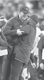  ?? MELANIE MAXWELL/DETROIT FREE PRESS ?? Michigan offensive coordinato­r Sherrone Moore picks up head coach Jim Harbaugh after their win on Monday.