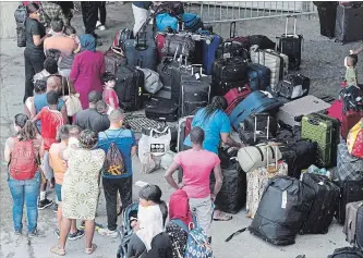  ?? PAUL CHIASSON THE CANADIAN PRESS ?? Asylum seekers line up to enter Montreal’s Olympic Stadium last summer. A ‘triage’ program was announced last year after Quebec and Toronto asked for federal help in dealing with an influx of asylum seekers.