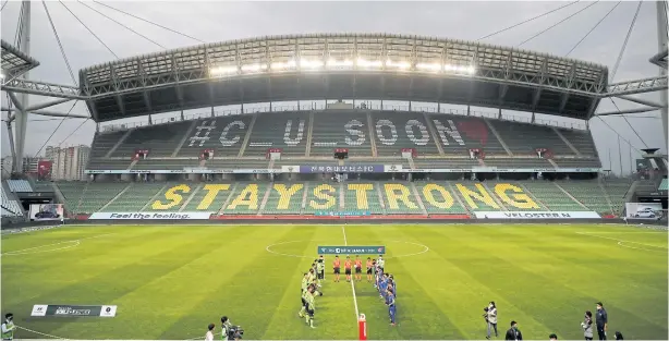  ?? REUTERS ?? Players of Jeonbuk Hyundai Motors, left, and Suwon Samsung Bluewings line up before their K-League match at Jeonju World Cup Stadium yesterday.