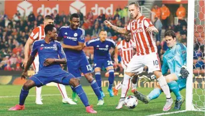  ??  ?? Chelsea goalkeeper Asmir Begovic gets a boot on the ball ahead of Stoke City forward Marko Arnautovic during yesterday’s League Cup fourth round match at the Britannia Stadium. – REUTERSPIX