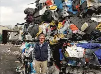  ?? GREGORY B. HLADKY/HARTFORD COURANT ?? Tom DeVivo, co-owner of Willimanti­c Waste Paper, stands near a massive bale of recycling plastic. The company used to get paid to send plastic to China, but now gives it away to a Canadian operation.