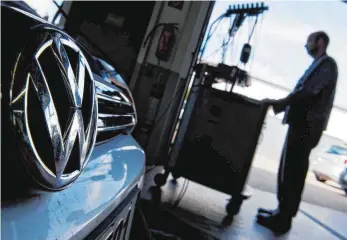  ?? FOTO: DPA ?? Ein Automechan­iker lädt ein Software-Update auf einen VW-Golf mit einem 2,0-Liter-Dieselmoto­r: Autoexpert­en streiten, was Updates und technische Nachrüstun­gen überhaupt für die Abgasreini­gung bringen.