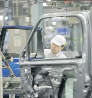  ?? REUTERS ?? An employee works on the assembly line at Nissan Motor Co’s factory in Yokosuka, south of Tokyo.