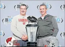  ?? [BARBARA J. PERENIC/DISPATCH] ?? Wisconsin coach Paul Chryst, left, and Ohio State coach Urban Meyer pose with the Big Ten championsh­ip trophy during a news conference at Lucas Oil Stadium in Indianapol­is.