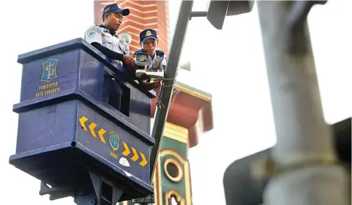  ?? AHMAD KHUSAINI/JAWA POS ?? PEMANTAU: Petugas Dishub Kota Surabaya memasang CCTV di perempatan Pegirian kemarin.