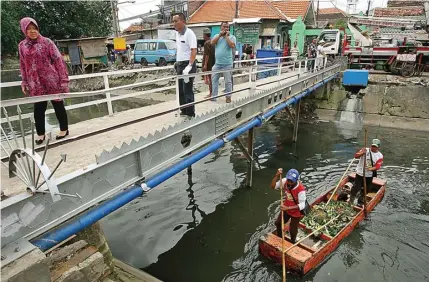  ?? AHMAD KHUSAINI / JAWA POS ?? TURUN LANGSUNG: Wali Kota Surabaya Tri Rismaharin­i memantau pembersiha­n dan penertiban di sekitar aliran Kali Pegirian kemarin.