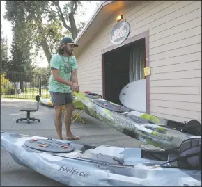  ?? BEA AHBECK/NEWS-SENTINEL ?? Assistant manager Bo Terra puts away a kayak at Headwaters Kayak at Lodi Lake in Lodi on Friday.
