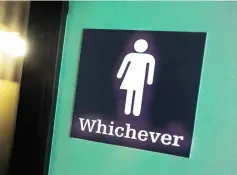  ??  ?? This file photo shows a gender neutral sign seen outside a bathroom at the Oval Park Grille restaurant in Durham, North Carolina. — AFP photo