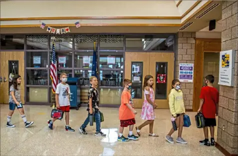  ?? Alexandra Wimley/Post-Gazette ?? Students walk through the hallway during the first day of school at Mars Area Elementary School on Wednesday in Mars. Masks are optional for students and teachers in the district.