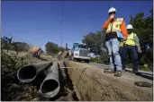  ?? JEFF CHIU — THE ASSOCIATED PRESS FILE ?? Paul Standen, senior director of undergroun­d regional delivery, second from right, and project manager Jeremy Schanaker, right, look on during a tour of a Pacific Gas and Electric crew burying power lines in Vacaville on Oct. 11, 2023.