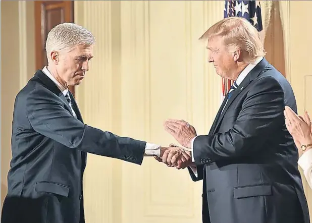  ??  ?? El presidente de EE.UU., Donald Trump, saluda al juez conservado­r Neil Gorsuch tras anunciarlo como candidato para el Tribunal Supremo