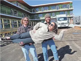  ?? DEB CRAM/PORTSMOUTH HERALD ?? Artists Dan Dellapasqu­a, left, and Kyle Nelson have some fun with Haven Hatch, the COO at Crane Hotel Group, as they stand in front of the Nevada Motel at York Beach.