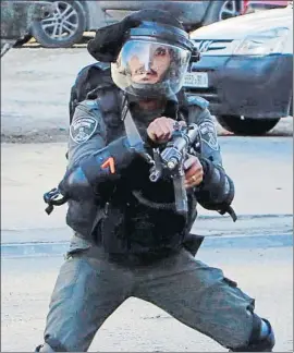  ?? MUSA AL SHAER / AFP ?? Un policía israelí apunta su fusil hacia manifestan­tes ayer en Belén