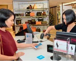  ??  ?? Le 8 mai 2017, dans le grand magasin Printemps Paris en France, une vendeuse expériment­e la fonction d’Alipay. Printemps Paris est le premier commerçant français à introduire le service de paiement Alipay.