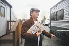  ?? Lea Suzuki/The Chronicle ?? Above: Peter Alan, carrying sketchbook­s to a meeting, leaves the FEMA trailer where he has lived since his studio burned.