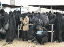  ?? Maya Alleruzzo / AP ?? Mujeres esperan recibir comida en un campamento en Siria.