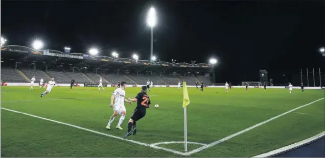  ??  ?? Daniel James intenta un pase desde la banda en la victoria del United ante el LASK con el estadio del equipo austriaco, Raiffeisen Arena, sin público.