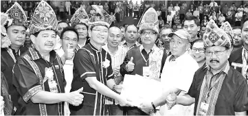  ??  ?? Madius (left) receiving the membership applicatio­n forms from Haam Balunsin on behalf of the new members in Paginatan.