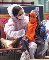  ?? — PTI ?? A passenger and her child wearing protective suits wait to board a plane at Kempegowda internatio­nal airport in Bengaluru on Tuesday.