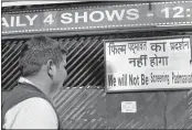  ??  ?? A visitor reads a notice affixed to a board outside a cinema hall over not screening the controvers­ial film 'Padmaavat' following threats issued by Karni Sena, in Bhopal on Thursday.