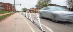  ?? ZHIHAN HUANG / MILWAUKEE JOURNAL SENTINEL ?? Wave delineator­s are placed to divide the bike lane and driving lane on North Hawley Road.