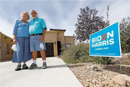  ?? LUIS SÁNCHEZ SATURNO/THE NEW MEXICAN ?? Lynn Roby, and her husband, John Roby, stand in front of their home Tuesday with their Joe Biden campaign sign. Their HOA in Villas di Toscana asked them to remove the sign, but John Roby refused and paid a fine.